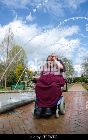 Equitazione donna Scooter attraverso un tunnel Fontana Foto Stock