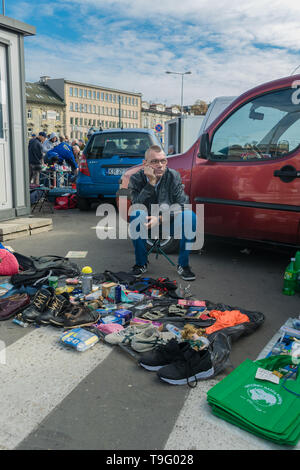 Cracovia in Polonia - 21 Settembre 2018: produttore polacco in attesa per gli acquirenti in un parcheggio. Egli è la vendita di usato scarpe e vestiti a Cracovia il Unitarg plac Foto Stock