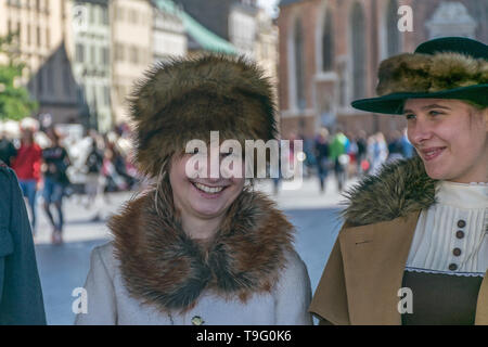 Cracovia in Polonia - 23 Settembre 2018: Elegante piuttosto giovane donna vestita di guerra mondiale I periodo abbigliamento sorridendo tra i turisti a Cracovia la piazza principale Foto Stock