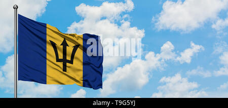 Bandiera di Barbados sventolare nel vento contro bianco torbido cielo blu. Concetto di Diplomazia e relazioni internazionali. Foto Stock