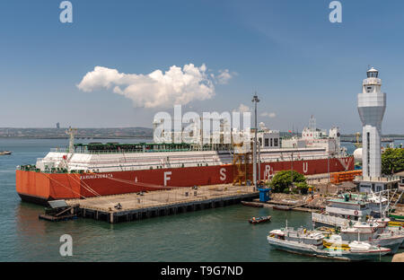 Bali, Indonesia - 25 Febbraio 2019: il bianco e il rosso deposito galleggiante e unità di rigassificazione, FSRU, LNG-nave nel porto di Benoa sotto luce blu del cielo. Foto Stock