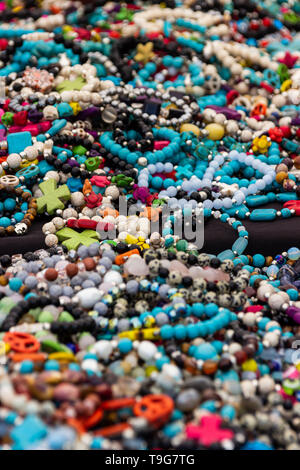 Colorato bracciali e collane giaceva su un tavolo in un festival all'aperto. Foto Stock