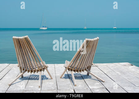 Sedie a sdraio sul dock, Caye Caulker, Belize Foto Stock