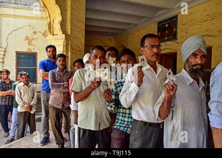 Patiala, Punjab (India). 19 Maggio, 2019. Gli elettori indiani visto che mostra le loro carte di identità in quanto la coda per esprimere il loro voto in corrispondenza di una stazione di polling durante la fase finale dell'India elezioni generali nel distretto di Patiala del Punjab.Il voto ha iniziato per la fase finale di Lok Sabha elezioni nel Punjab, Bihar, West Bengal, Madhya Pradesh, Uttar Pradesh, Himachal Pradesh, nello stato del Jharkhand e Chandigarh. Oltre 10.01 lakh gli elettori decideranno le sorti di 918 candidati. Il conteggio dei voti si svolgerà il 23 maggio hanno detto i funzionari. Credito: Saqib Majeed SOPA/images/ZUMA filo/Alamy Live News Foto Stock