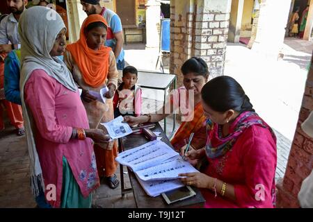 Patiala, Punjab (India). 19 Maggio, 2019. Un funzionario visto il controllo per i nomi degli elettori in corrispondenza di una stazione di polling durante la fase finale dell'India elezioni generali nel distretto di Patiala del Punjab.Il voto ha iniziato per la fase finale di Lok Sabha elezioni nel Punjab, Bihar, West Bengal, Madhya Pradesh, Uttar Pradesh, Himachal Pradesh, nello stato del Jharkhand e Chandigarh. Oltre 10.01 lakh gli elettori decideranno le sorti di 918 candidati. Il conteggio dei voti si svolgerà il 23 maggio hanno detto i funzionari. Credito: Saqib Majeed SOPA/images/ZUMA filo/Alamy Live News Foto Stock