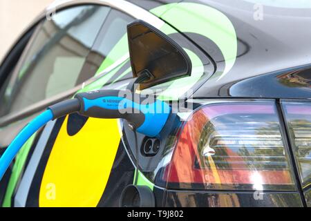 Schleswig, Deutschland. 19 Maggio, 2019. 19.05.2019, un modello di Tesla 3 veicolo elettrico viene caricato withtels un tappo di carica della Società Mennekes sul Gottorfer Landmark. Dettaglio del processo di carica. | Utilizzo di credito in tutto il mondo: dpa/Alamy Live News Foto Stock