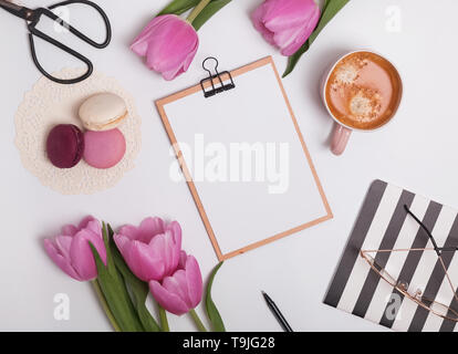 Stile femminile luogo di lavoro con tulipani e caffè. Appunti mock-up Foto Stock