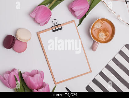 Stile femminile luogo di lavoro con tulipani e caffè. Appunti mock-up Foto Stock