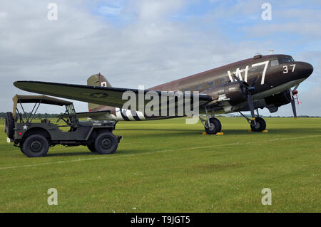 Douglas C-47 Skytrain piano di trasporto nel periodo marcature camouflage - compresi D giorno 'invasione strisce' - con Willys MB Jeep. Whiskey sette Foto Stock