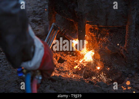 Macchina di saldatura con metallo in fusione scende e le scintille di scintille. Foto Stock