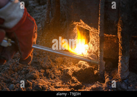 Macchina di saldatura con metallo in fusione scende e le scintille di scintille. Foto Stock