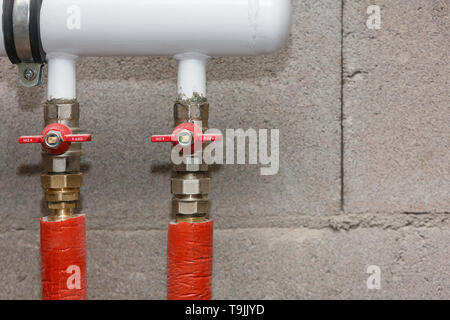 Gru sanitari con tubi di alimentazione dell'acqua, isolato con trecce colorate. Foto Stock