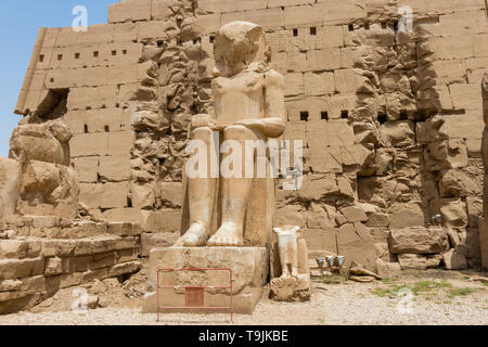 Statua seduto di fronte al settimo pilone del tempio di Amon, Karnak Luxor Egitto Foto Stock