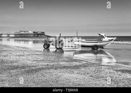 Cittadina in stile vittoriano del Cromer riflessa nella sabbia bagnata con la bassa marea, Norfolk, East Anglia Foto Stock