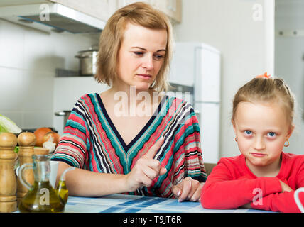 Sconvolto giovane madre svergognare la figlia per comportamento scorretto in interni domestici Foto Stock