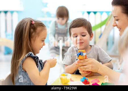 Bambini su lezioni di arte con insegnante in asilo nido Foto Stock