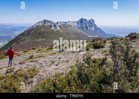 Un uomo su un sentiero escursionistico e vista su Recilla picco in Cantabria mountain range tra La Rioja e Alava, Paesi Baschi Foto Stock