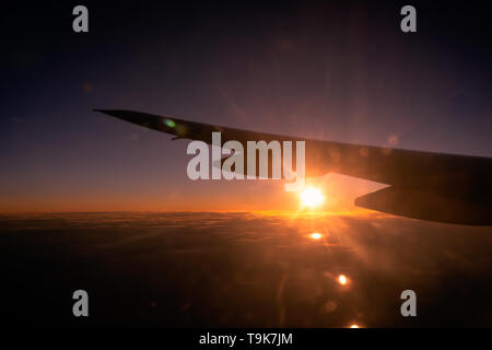 Bellissima alba o tramonto sopra le nuvole attraverso la finestra aereo ad ala. Viaggi e trasporti i concetti. Foto Stock