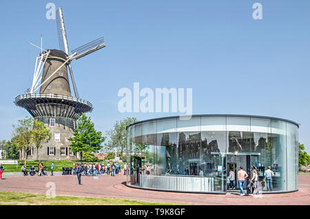 Leiden, Paesi Bassi, 18 Maggio 2019: tradizionale mulino a vento De Valk e il moderno vetro circolare entrata del garage sotto Lammermarkt squ Foto Stock