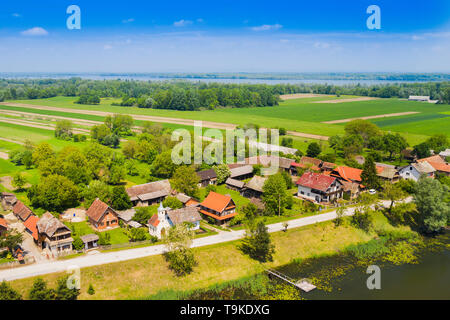 Bella e verde paesaggio di campagna nel parco naturale di Lonjsko polje, Croazia da aria, vista panoramica del villaggio Muzilovcica, fiume Sava in primavera Foto Stock