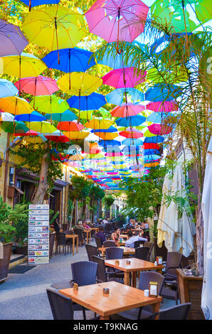 Nicosia, Cipro - 4 OTT 2018: ristorante esterno giardino con ombrelloni colorati la decorazione della parte superiore della strada. Popolare località turistica in città Foto Stock