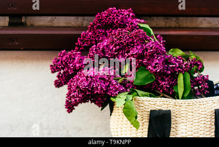 Primavera o estate foto di shopper con grande mazzo di vivida viola fiori lilla Foto Stock