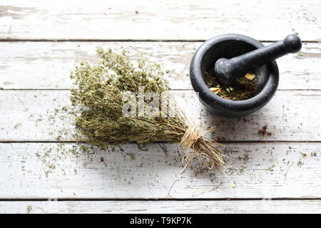 Composizione di erbe essiccate. Miscela aromatica grattugiato nella malta. Sfondo, composizione orizzontale con spazio per testo, vista dall'alto Foto Stock