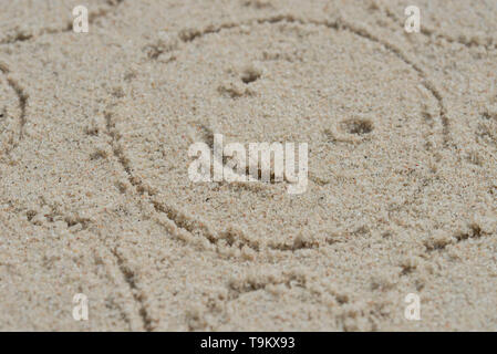 Sun sorridente sul disegno di sabbia closeup Foto Stock