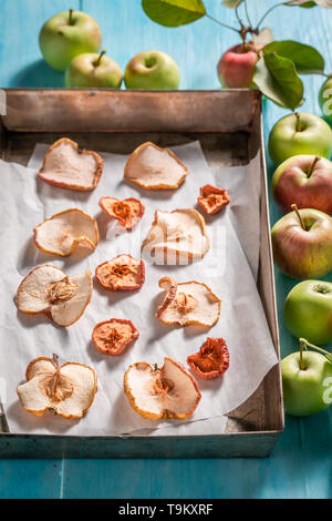 Dolce di mele disidratate fatta di frutta fresca sul tavolo blu Foto Stock