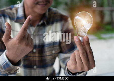 Una mano azienda è la luce della lampadina, idee creative concetto, lampadina per la nuova idea, oggetto design per pensare - Immagine - Immagine Foto Stock