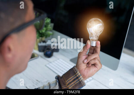 Una mano azienda è la luce della lampadina, idee creative concetto, lampadina per la nuova idea, oggetto design per pensare - Immagine - Immagine Foto Stock