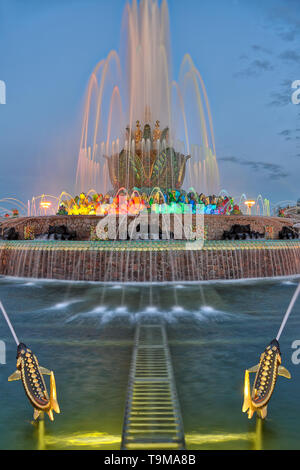 Fontana dei fiori di pietra e pesci dorati al crepuscolo primaverile a VDNKh, Mosca. Foto Stock