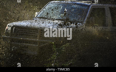 Off road auto o lo sport utility vehicle supera gli ostacoli. Auto Racing, la concorrenza e il concetto di energia auto pozza di incrocio con la sporcizia splash Foto Stock