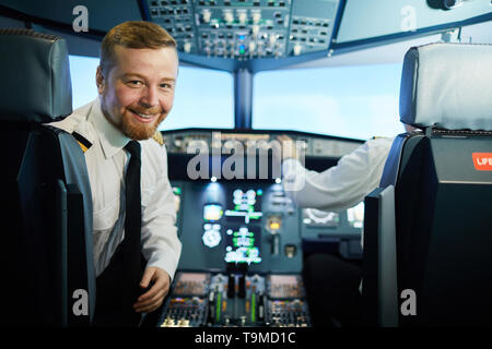 Fiducioso barbuto pilota nel cockpit Foto Stock