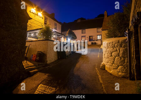 Strada stretta e il Cadgwith Cove Inn di notte, nel villaggio di pescatori di Cagdwith,Cornwall,l'Inghilterra,UK. La locanda è il centro della piccola comunità Foto Stock
