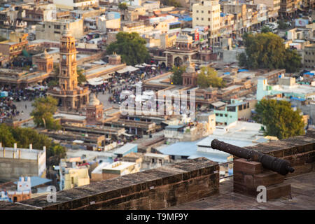 Splendida vista del Ghanta Ghar Clock Tower e il mercato Sadar in background e un cannone sulla Forte Mehrangarh in primo piano. Foto Stock
