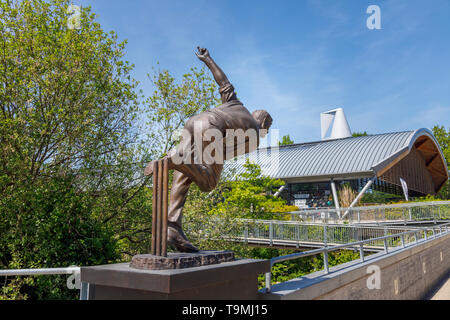 Statua di bronzo di giocatore di cricket Sir Alec Bedser sul ponte Bedser, una passerella sul Basingstoke canale che collega il WWF-UK sede al centro della città Foto Stock
