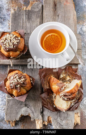 Muffin fatti in casa e tè aromatizzato su un rustico sfondo di legno. Close-up. Vista superiore Foto Stock