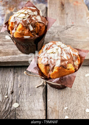 Close-up muffin al cioccolato e mandorle in un rustico sfondo. Foto Stock