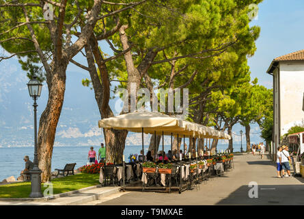 TORRI DEL BENACO SUL LAGO DI GARDA, Italia - Settembre 2018: Outdoor area da pranzo presso un ristorante sul lungomare sul bordo del lago di Garda Foto Stock