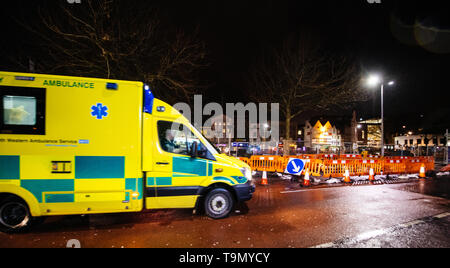 London, Regno Unito - Mar 5, 2017: Giallo sfocati NHS Ambulance guida veloce sul riparato con lavori stradali street nel centro di Londra di notte Foto Stock