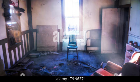 Abbandonare la stanza in abusato della vecchia casa centrato sedia con luminosi raggi di luce delle Tossicodipendenze nascondiglio Foto Stock