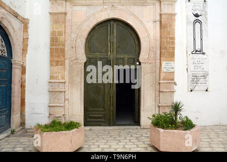 Il tradizionale islamica porta in legno di un vecchio del XVI secolo convertita casa in un vicolo della medina (città vecchia) di Tunisi, Tunisia. Foto Stock
