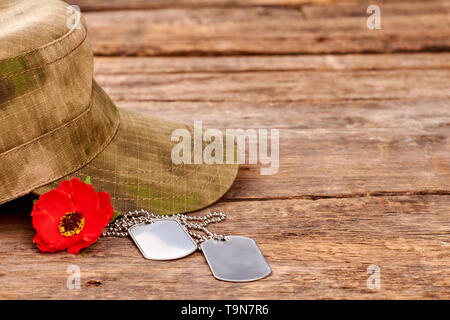 Cappello militare, dog tag e papavero rosso vicino. Foto Stock