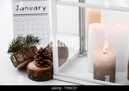 Candele accese e decorazioni di Natale sulla tavola, primo piano Foto Stock