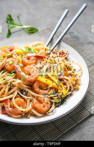 Piastra con saporiti spaghetti cinesi e gamberetti su tavola, primo piano Foto Stock