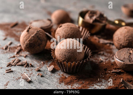 Gustosi tartufi di cioccolato con polvere di cacao sulla tabella grigia Foto Stock