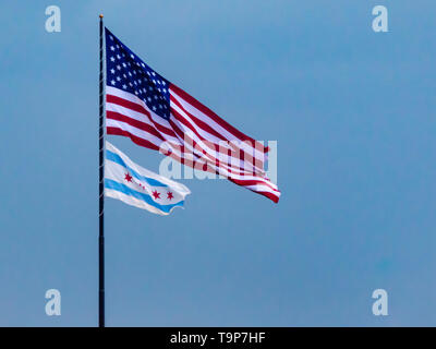 Stati Uniti d'America bandiera americana e la città di Chicago bandiera al vento contro un cielo blu chiaro. Il patriottismo. Simbolo. Foto Stock