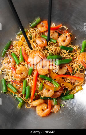 Tagliatelle cinesi con gamberi e le verdure nel wok, primo piano Foto Stock