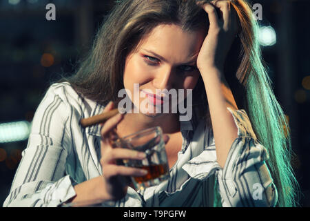 Giovane donna di bere alcolici e fumare il sigaro in bar Foto Stock